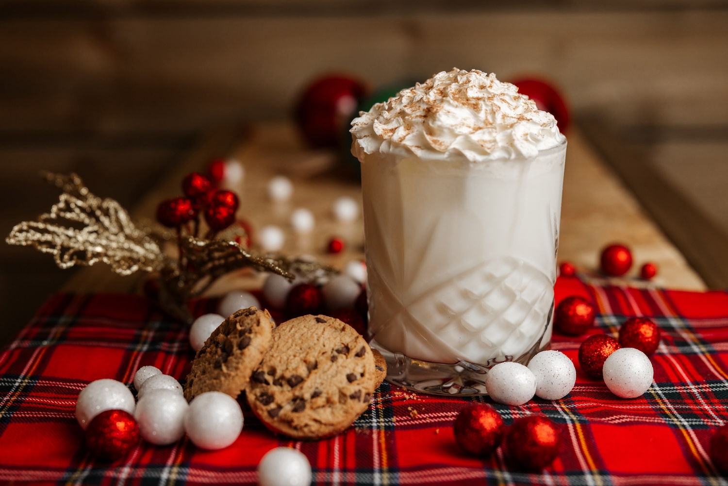 A whipped-cream topped festive drink on a tartan cloth